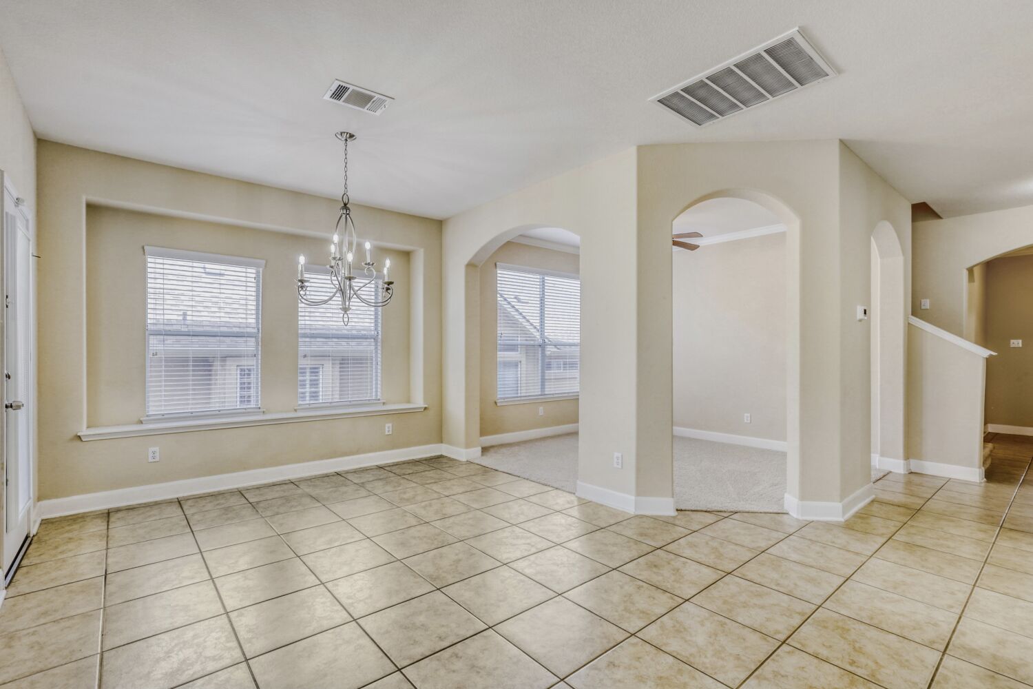 24 Stone Terrace Drive Austin, TX 78734 - Photo 16 of 31 Unfurnished dining area with arched walkways, a chandelier, and light tile patterned floors