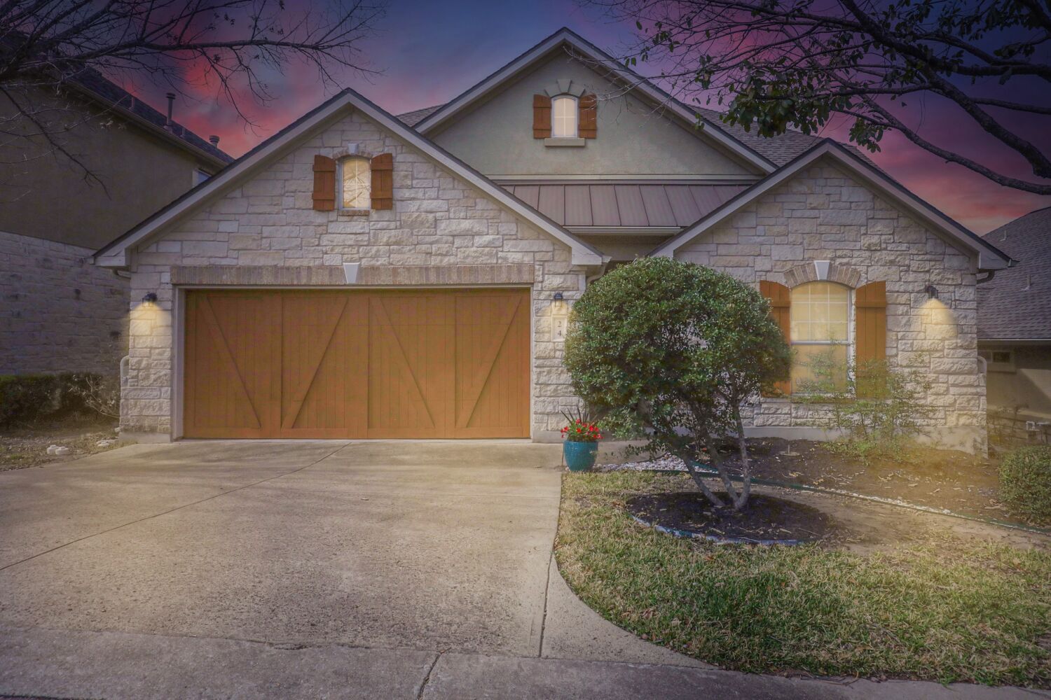 24 Stone Terrace Drive Austin, TX 78734 - Photo 2 of 31 Welcome home to your lock'n leave Lakeway gem. Nestled in the heart of Lakeway, walkable to grocery, dining and restaurants. The epitome of low-maintenance Lakeside living. Front facade featuring stone siding, a garage, driveway, and a standing seam roof
