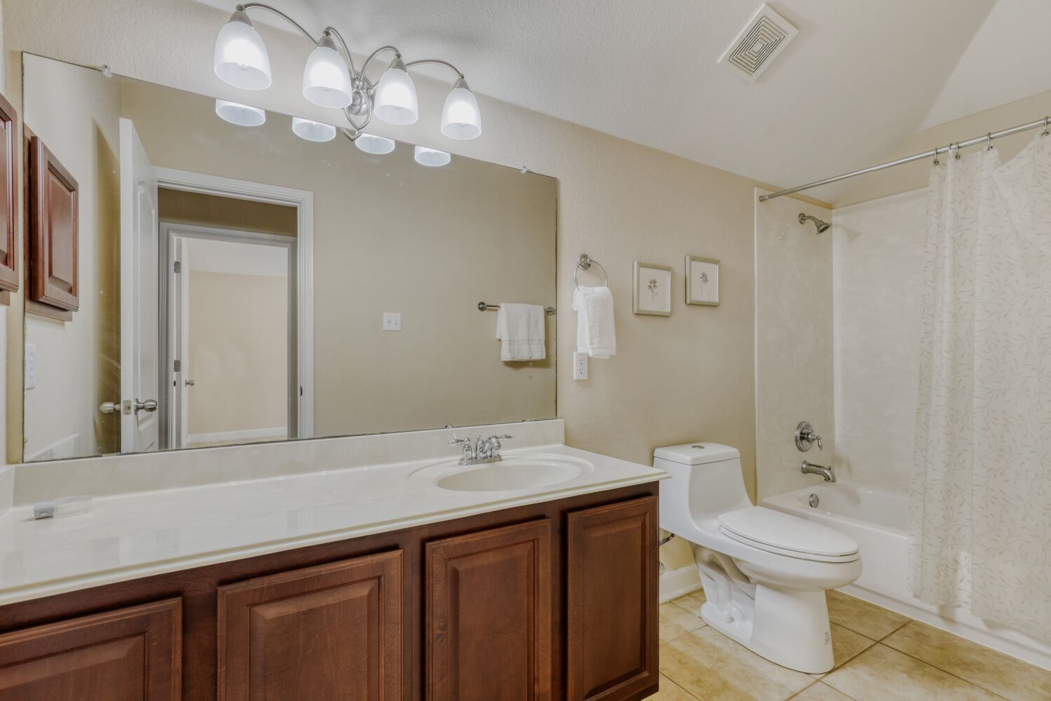 24 Stone Terrace Drive Austin, TX 78734 - Photo 19 of 31 Downstairs Bathroom featuring vanity, shower / tub combo with curtain, and light tile patterned flooring
