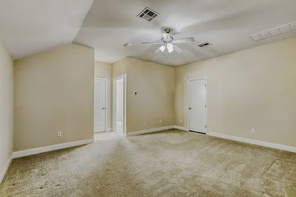 an empty room with a window and a fan