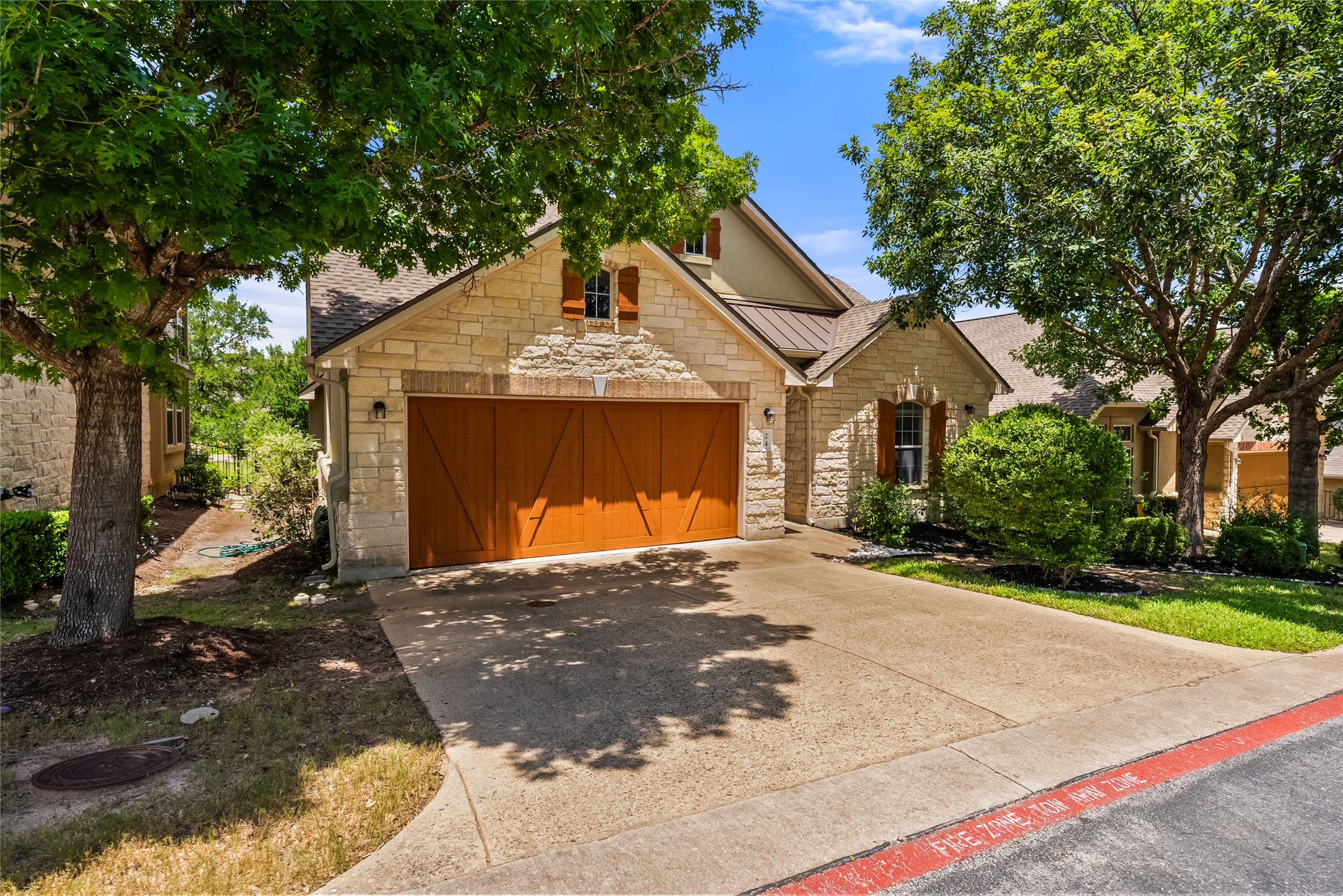 24 Stone Terrace Drive Austin, TX 78734 - Photo 28 of 31 This photo was taken in spring when the landscaping was lush and growing, so it will soon look like this!
Stone siding, an attached garage, and a standing seam roof.