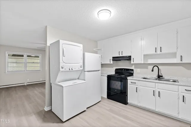 a kitchen with stainless steel appliances granite countertop white cabinets stove and a refrigerator