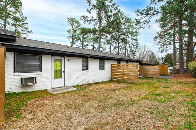 a view of a house with wooden fence and a large tree