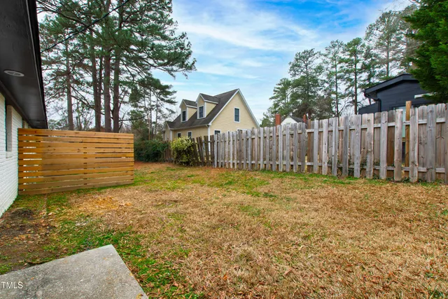 a view of a yard with wooden fence
