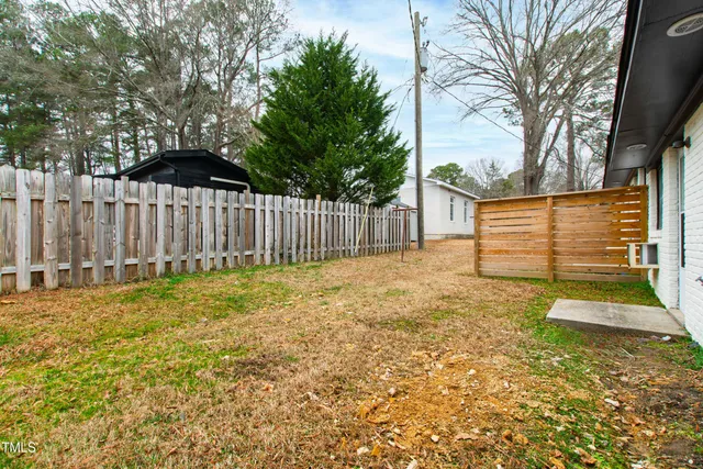 a view of backyard of house with large trees