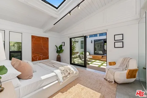 a bedroom with bed and glass windows