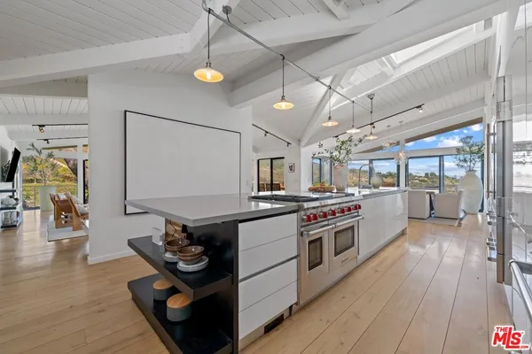 a kitchen with stainless steel appliances granite countertop a stove and a wooden floors