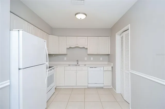 a kitchen with white cabinets and white appliances