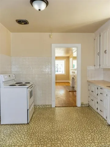 a kitchen with granite countertop a stove a sink and a refrigerator