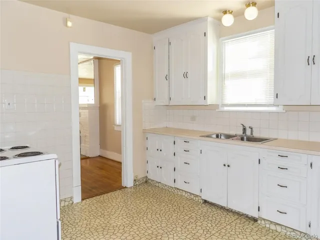 a kitchen with granite countertop white cabinets and white appliances