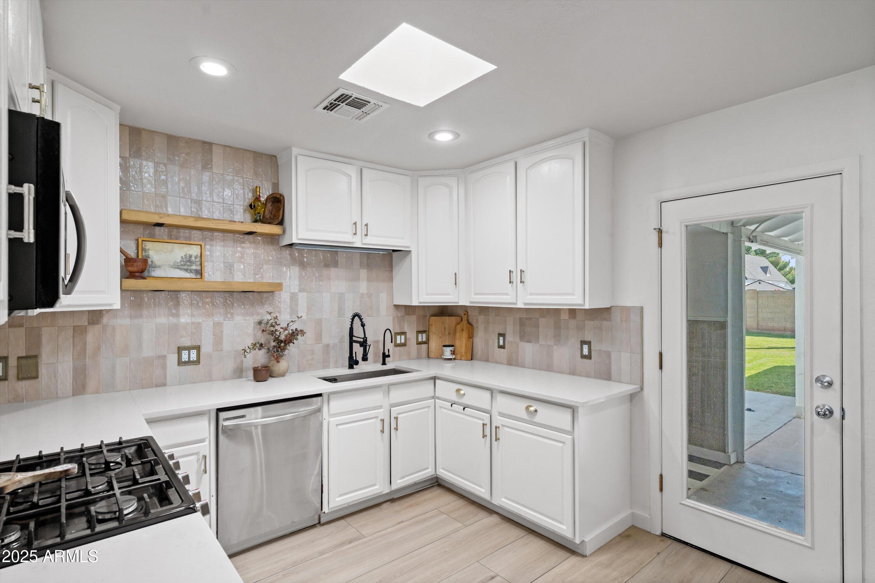 2201 East Weldon Avenue Phoenix, AZ 85016 - Photo 12 of 41 a kitchen with white cabinets and appliances