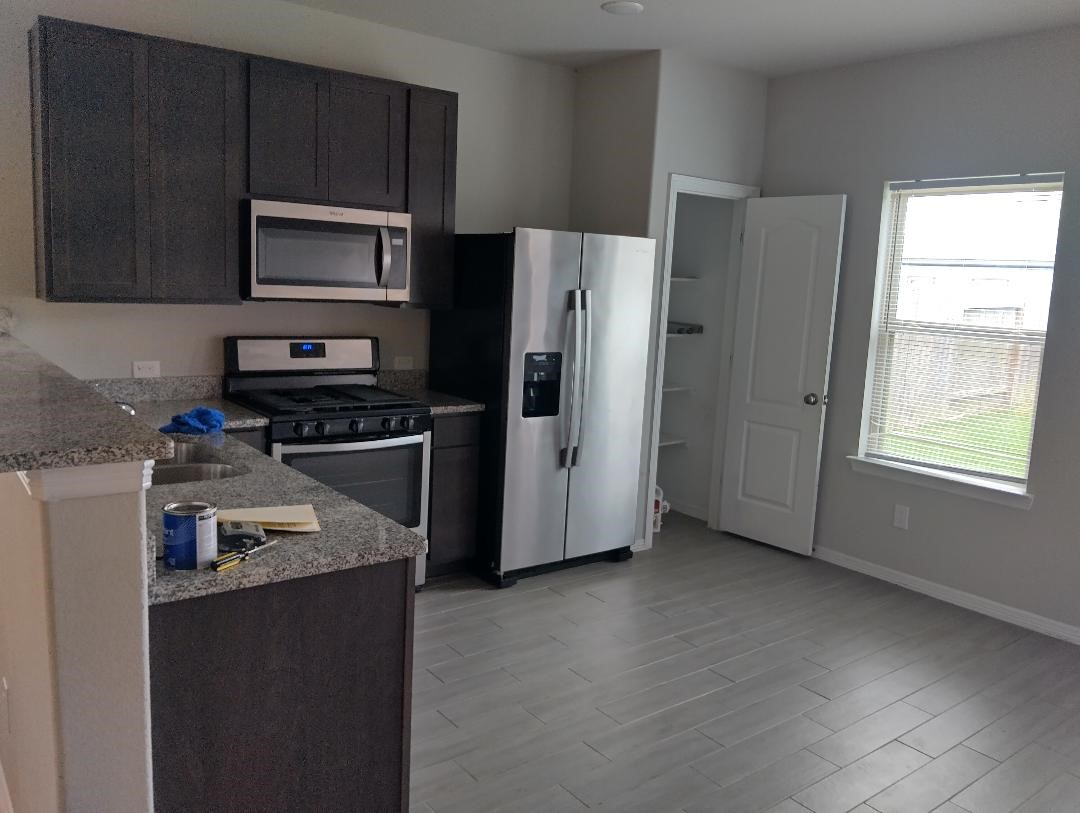 24807 Russet Bluff Trail Houston, TX 77336 - Photo 2 of 6 a kitchen with stainless steel appliances granite countertop a refrigerator stove and microwave