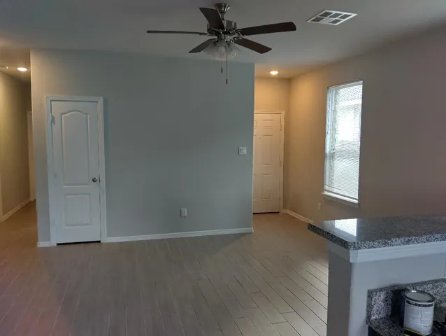 an empty room with fan and windows