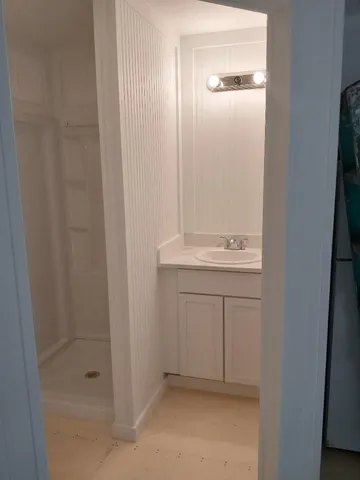 a bathroom with a sink a shower and a mirror