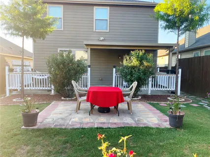 a view of a table and chairs in backyard of the house