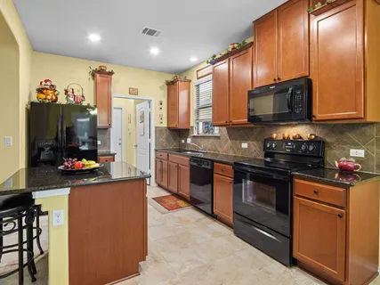 a kitchen with stainless steel appliances granite countertop a refrigerator and a stove