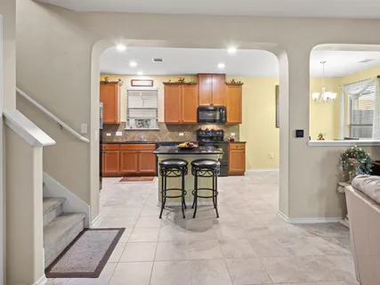 a dining room with granite countertop a sink dishwasher a dining table and chairs with wooden floor