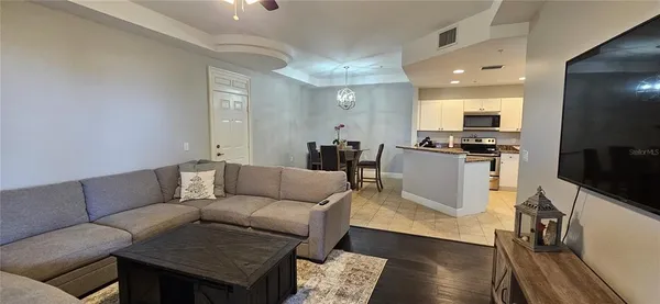 a living room with furniture a flat screen tv and kitchen view