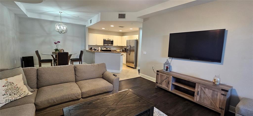 1502 Southwest 50th Street, Unit 104 Cape Coral, FL 33914 - Photo 7 of 18 a living room with furniture and a flat screen tv