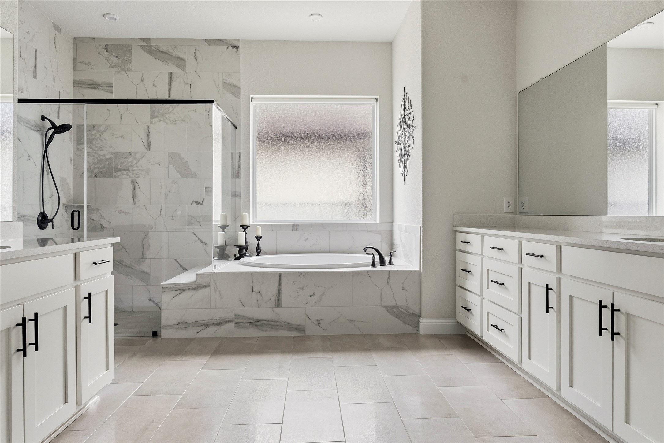 4513 Vieste View Leander, TX 78641 - Photo 28 of 40 Spacious bathroom featuring a built-in tub, separate shower with a glass enclosure, dual vanity cabinetry with white countertops, and light-toned floor tiling