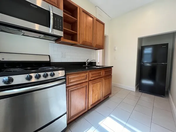 a kitchen with granite countertop a stove and a refrigerator