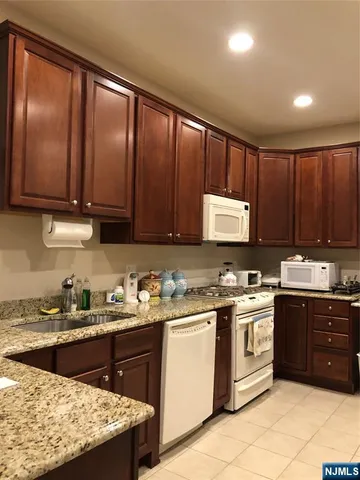 a kitchen with a sink stove top oven and cabinets