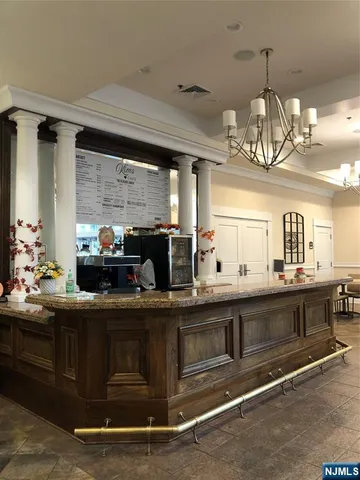 a kitchen with kitchen island granite countertop a sink stainless steel appliances granite counter tops and a view of living room