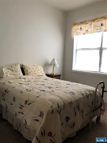 a bedroom with a bed that has a blanket on it and next to a window