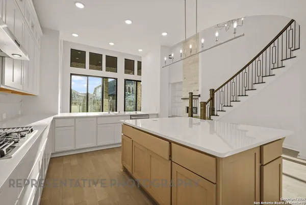 a kitchen with counter top space and windows