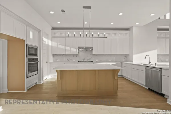 a kitchen with stainless steel appliances granite countertop a stove a sink and a refrigerator
