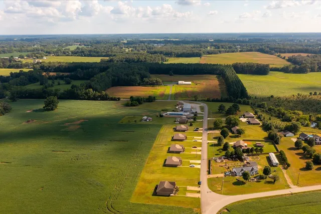 a view of a house with a big yard and large trees