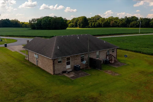 an aerial view of a house with a yard and lake view
