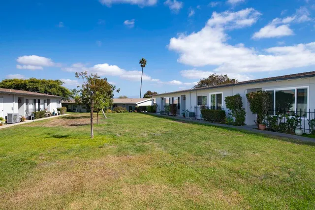 a view of a house with backyard and sitting area
