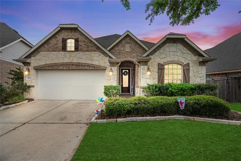 a front view of a house with a yard and green space