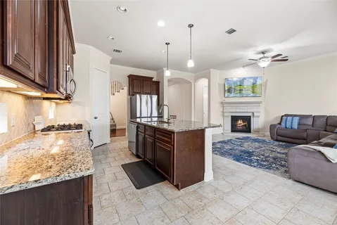 a large kitchen with kitchen island granite countertop a sink and a stove