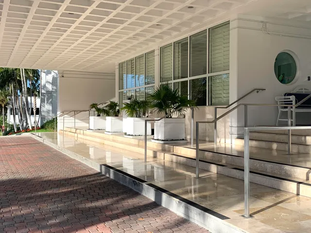 a living room with couches a flat screen tv and kitchen view