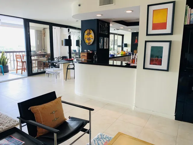a hallway with painting on the wall and a potted plant