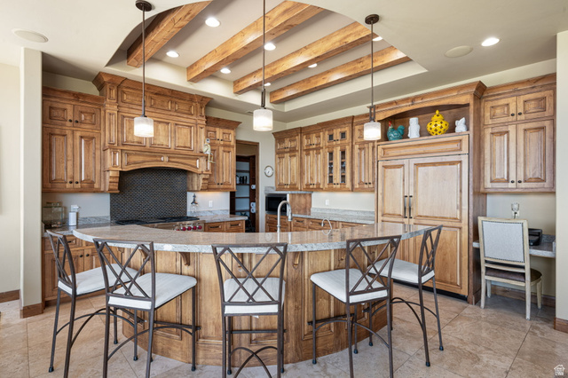 2331 West Entrada Trail, Unit 61 St. George, UT 84770 - Photo 12 of 69 Gourmet kitchen featuring custom wood cabinetry, a large curved island with a stone countertop, a built-in refrigerator, and a dedicated desk area
