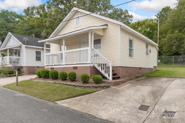 a view of a white house with a yard and plants