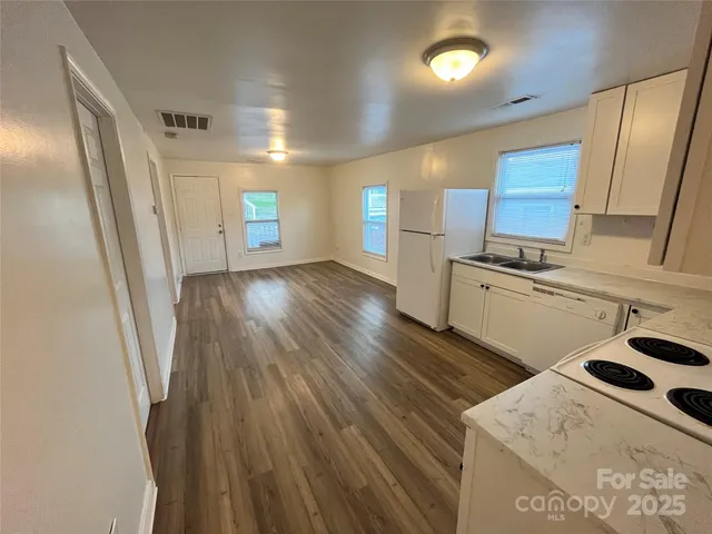 a kitchen with granite countertop a sink a stove and refrigerator