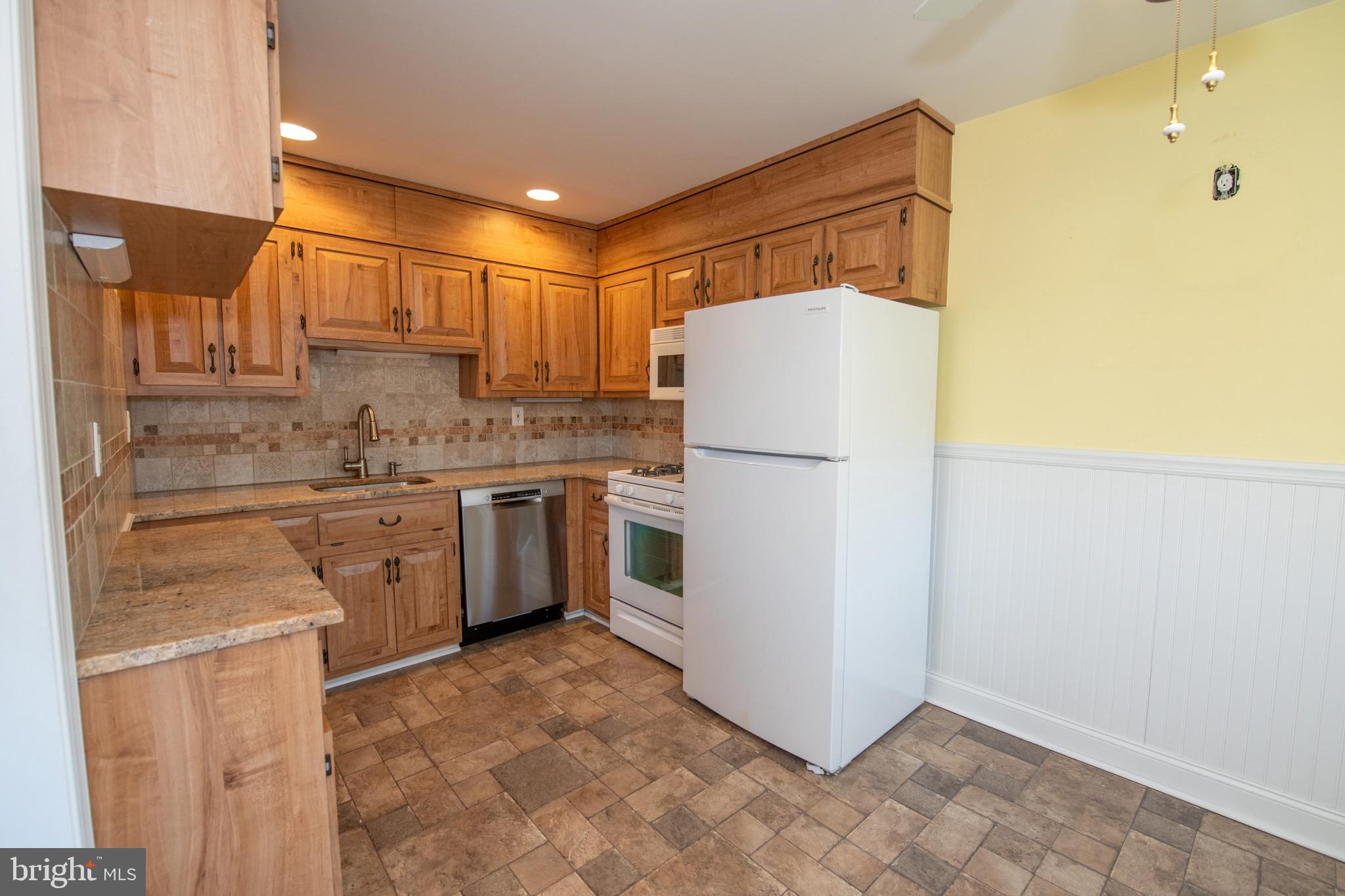 3210 Ancona Road Philadelphia, PA 19154 - Photo 19 of 46 a kitchen with a white refrigerator a sink and cabinets