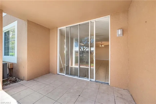 a view of an empty room with wooden floor and a bathroom