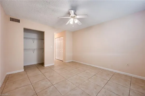 an empty room with a ceiling fan and carpet