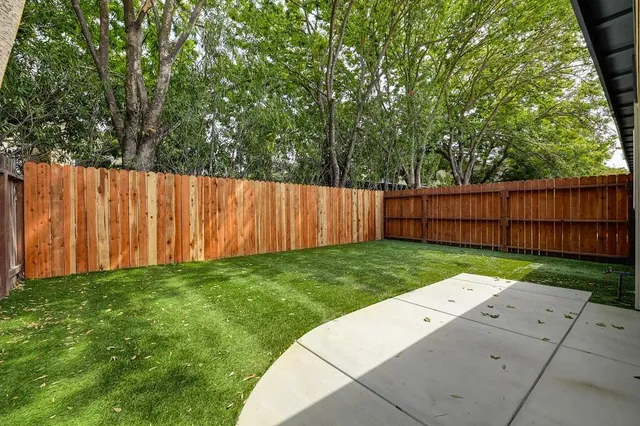 a view of an empty room with wooden floor and windows