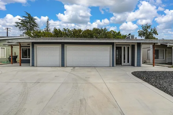 a kitchen with a sink a refrigerator and a stove top oven with wooden floor