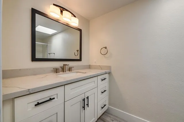 a view of a backyard with large trees and wooden fence