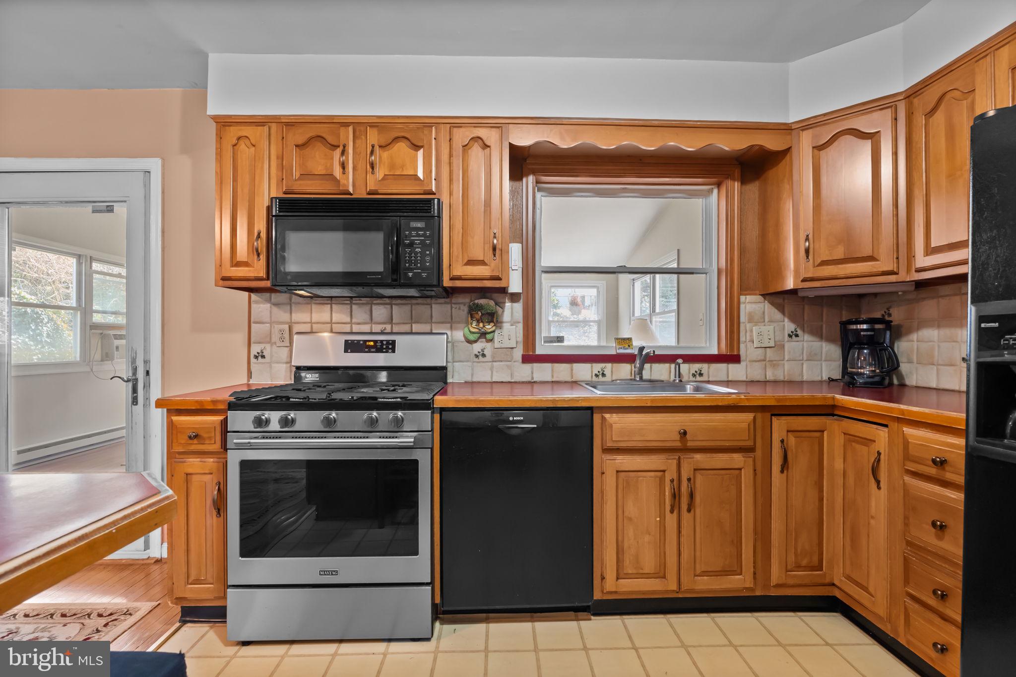211 Rolling Hill Road Elkins Park, PA 19027 - Photo 11 of 41 a kitchen with stainless steel appliances granite countertop a stove microwave and sink