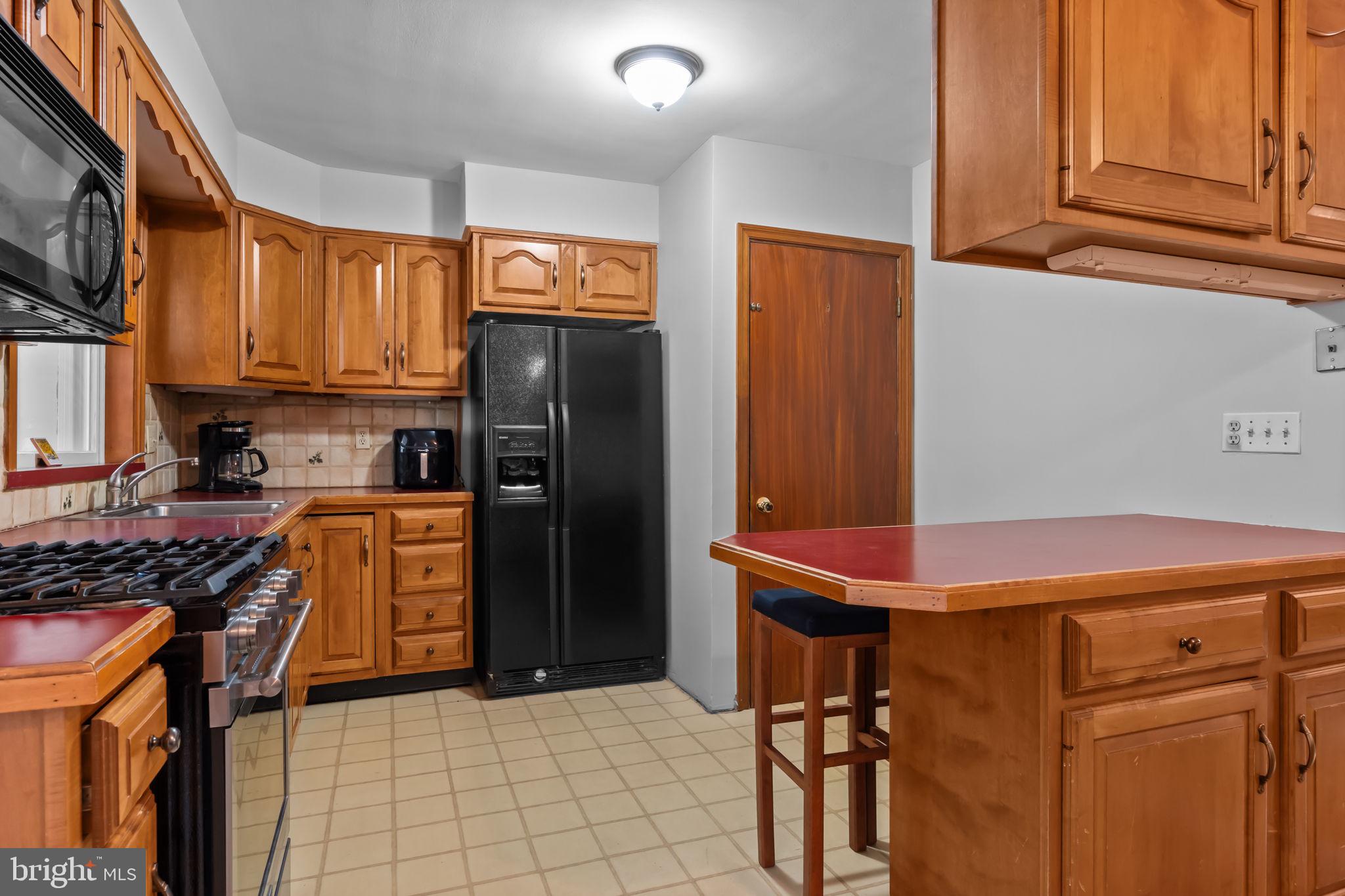 211 Rolling Hill Road Elkins Park, PA 19027 - Photo 10 of 41 a kitchen with stainless steel appliances a stove a refrigerator and cabinets
