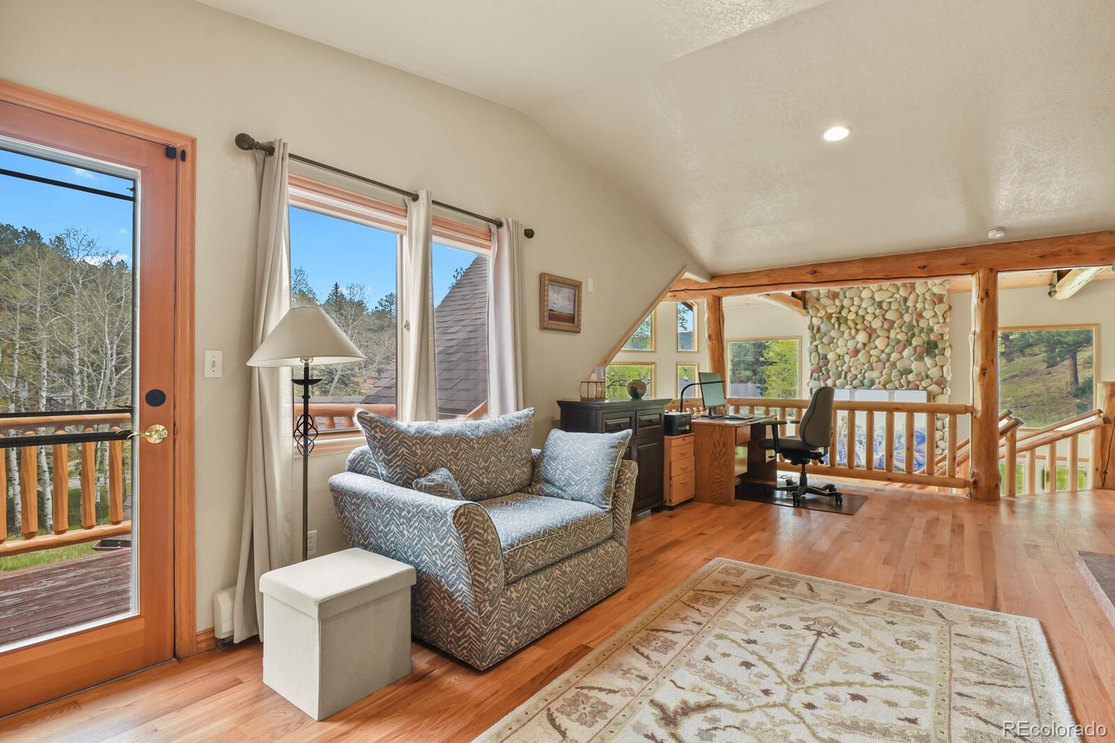 417 Witter Gulch Road Evergreen, CO 80439 - Photo 34 of 50 a living room with furniture and a large window with outer view
