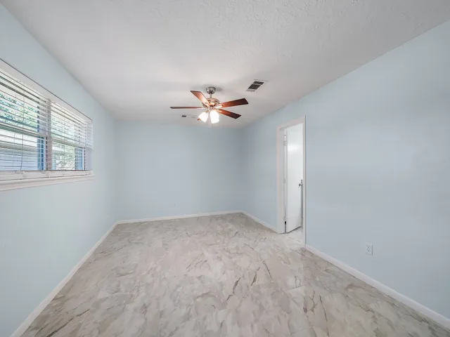 a view of a livingroom with a ceiling fan and window